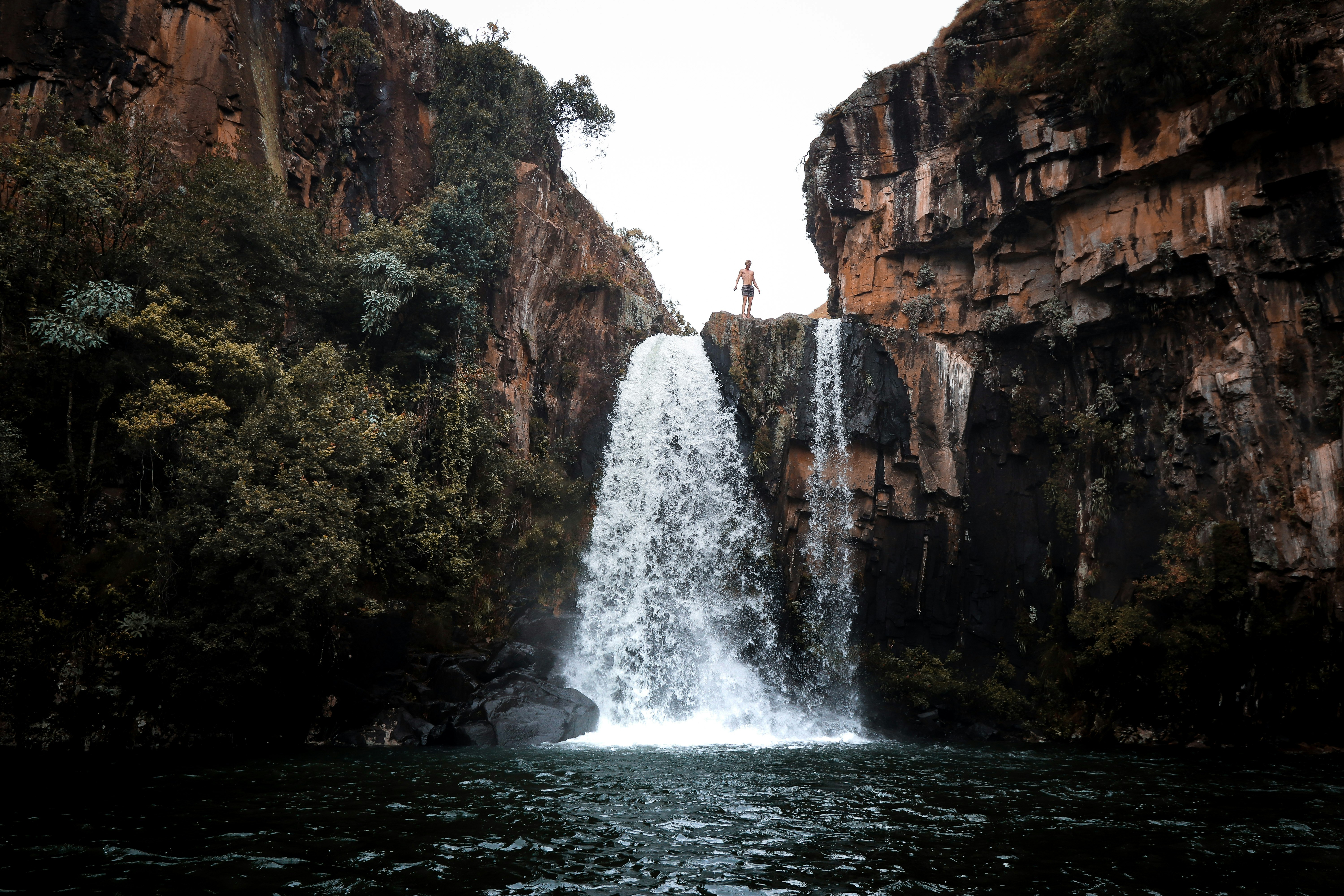 man standing on waterfalls top